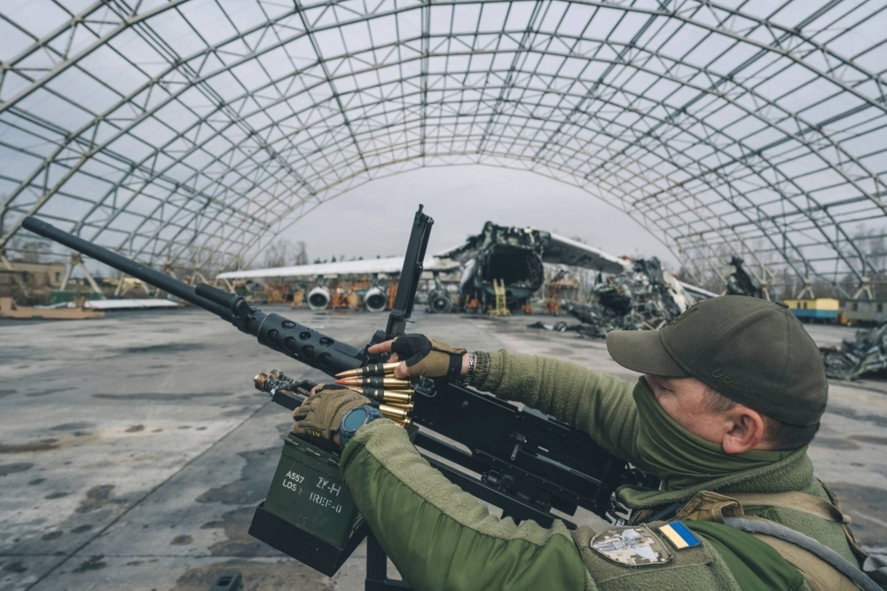 A Ukrainian soldier loads ammunition into an M2 Browning machine gun. 