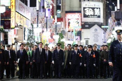 Police officers conduct a special inspection of Shinjuku Ward's Kabukicho in Tokyo in December.