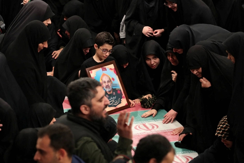The family of a member of the Islamic Revolutionary Guard Corps who was killed in the Israeli airstrike mourn during a funeral ceremony in Tehran on Thursday.