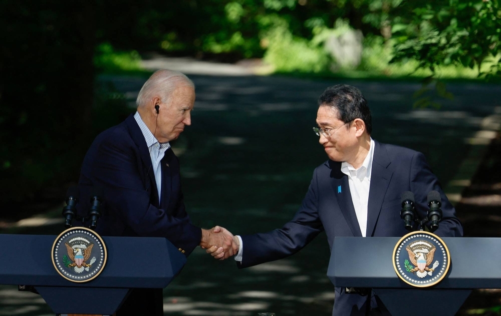 Prime Minister Fumio Kishida shakes hands with U.S. President Joe Biden during a trilateral summit at Camp David near Thurmont, Maryland, in August.