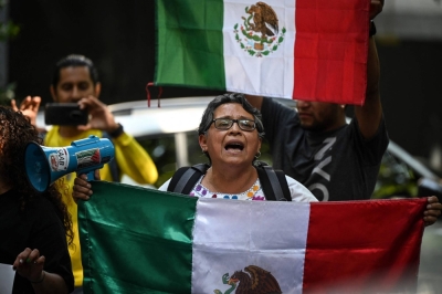 People holding Mexican flags protest outside the Ecuadorian Embassy in Mexico City on Saturday, following the severing of diplomatic relations between the two countries. 