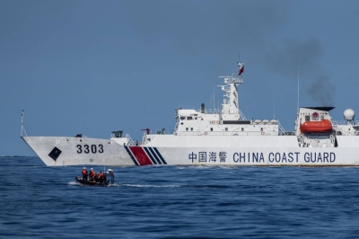 A boat carrying Philippine Coast Guard personnel moves past a China Coast Guard ship during a resupply mission in the disputed South China Sea on Nov. 10, 2023.