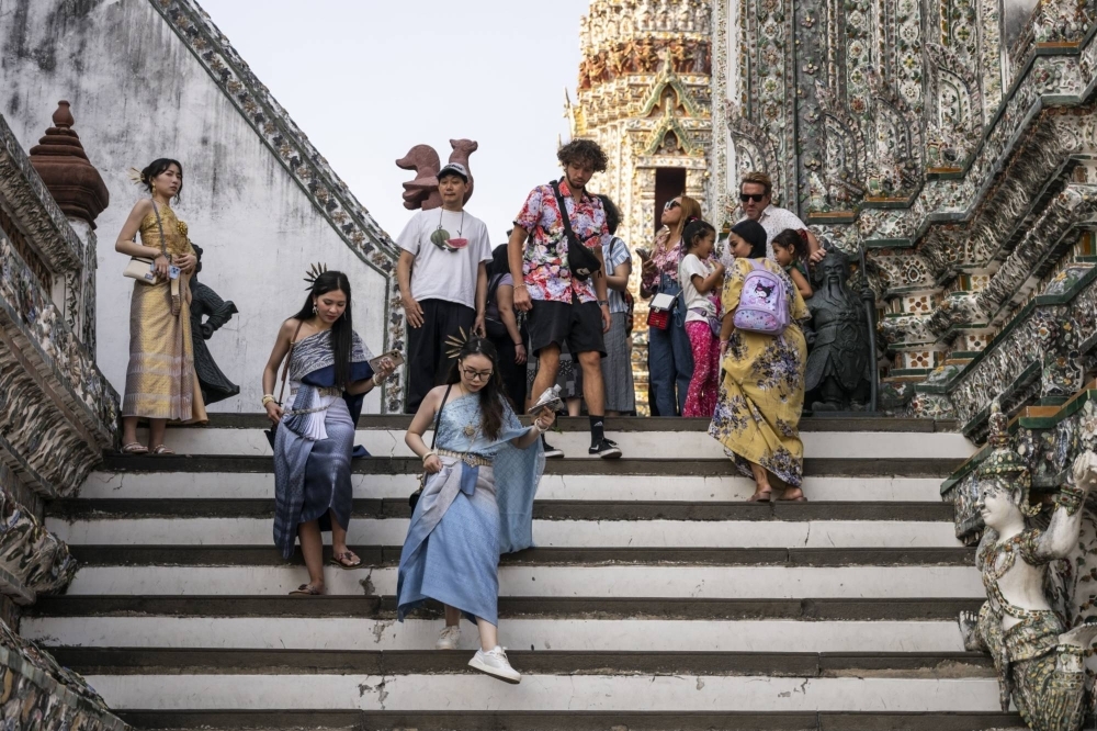Tourists visit Wat Arun Ratchawararam Ratchawaramahawihan in Bangkok in January.