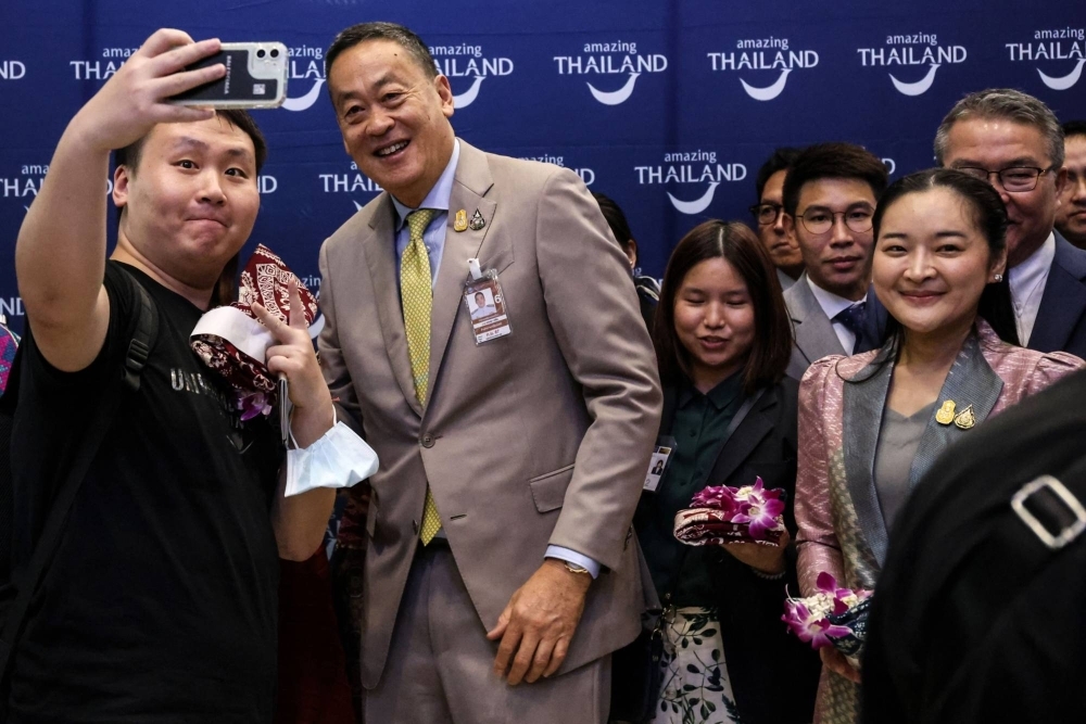 Prime Minister Srettha Thavisin poses for photographs with visitors during an event to welcome inbound tourists from China at Suvarnabhumi Airport in Bangkok on Sept. 23, 2023.