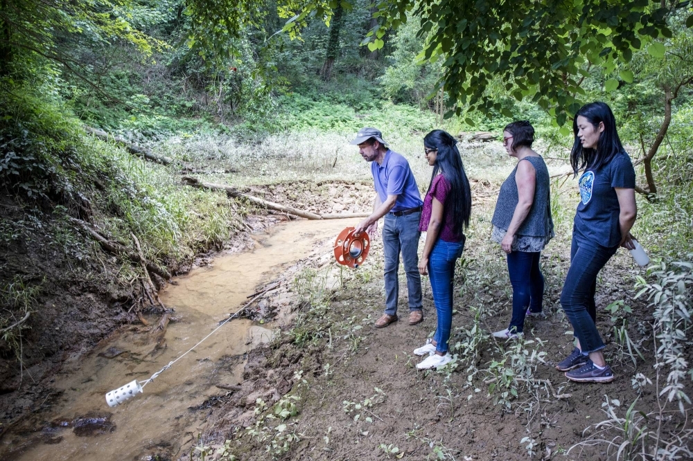 Detlef Knappe, a researcher at North Carolina State University who has focused on PFAS, leads students to collect water samples at the William O. Huske Dam in Fayetteville, North Carolina, in 2021.