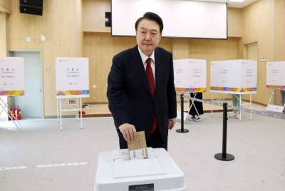 South Korean President Yoon Suk-yeol casts his ballot during early voting in parliamentary elections at a polling station in Busan, South Korea, on Friday, ahead of Election Day on Wednesday.