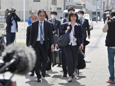Health ministry officials head to a Kobayashi Pharmaceutical factory in the city of Osaka on March 30 to conduct a search of the premises.