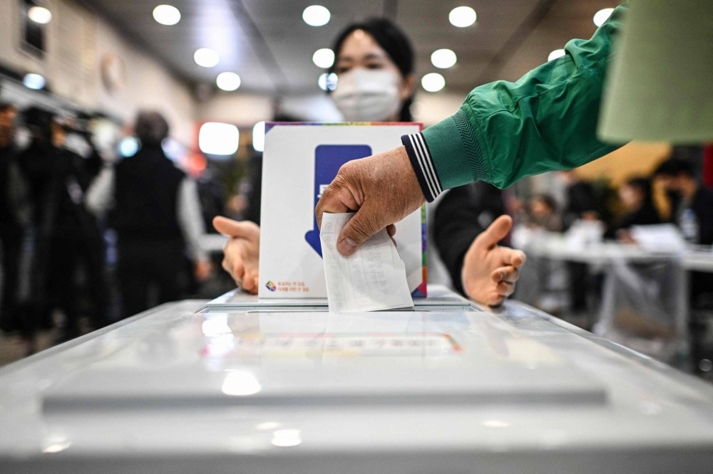 A voter casts their ballot at a polling station in Seoul early on Wednesday. 
