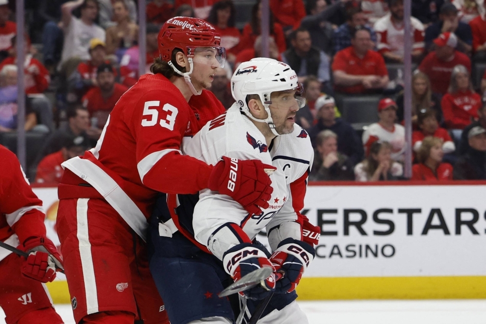 Red Wings defenseman Moritz Seider and Capitals winger Alex Ovechkin fight for position at Little Caesars Arena in Detroit on Tuesday. 