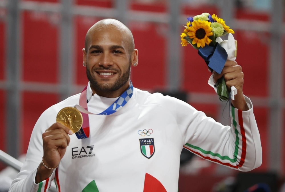 Italy's Marcell Jacobs celebrates with his gold medal after winning the men's 100-meter race during the 2020 Tokyo Olympics. 