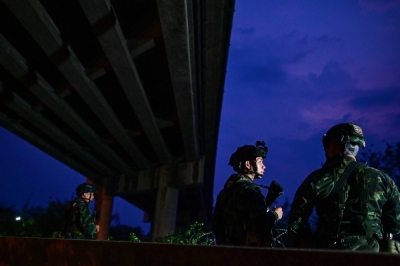 Thai military personnel stand guard overlooking the Moei river near the Tak border checkpoint with Myanmar, in Thailand's Mae Sot district on Monday.