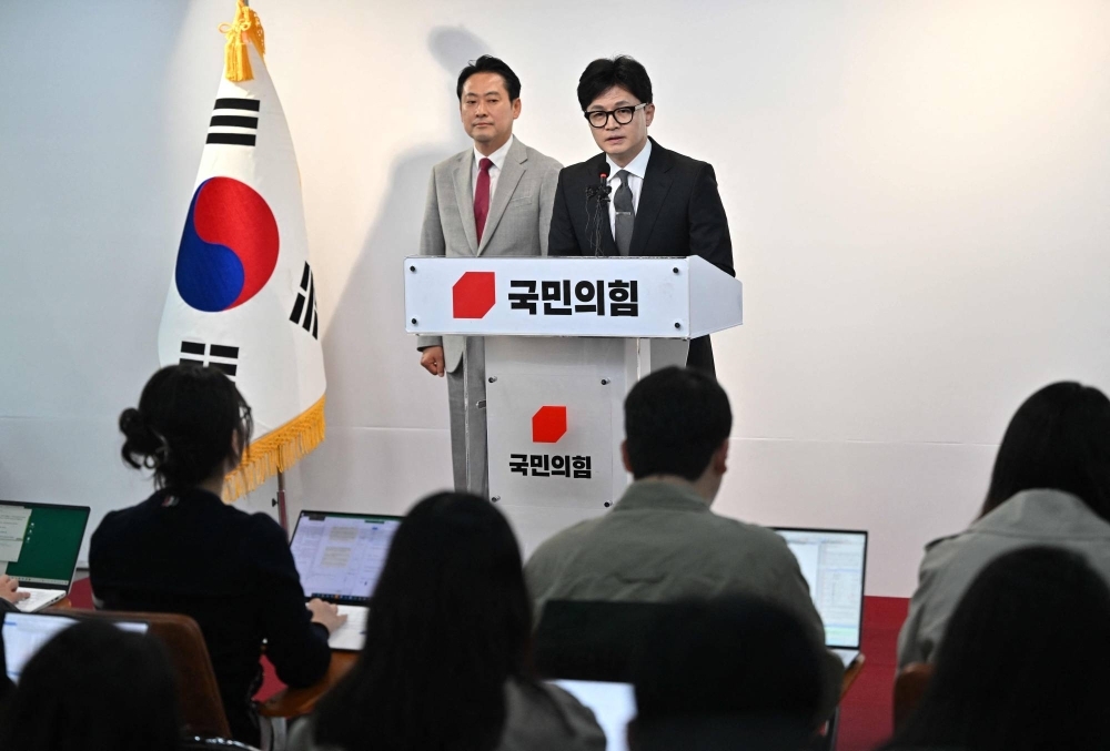 South Korea's ruling People Power Party's leader Han Dong-hoon (R) speaks during a press conference on the parliamentary election at the party's headquarters in Seoul on Thursday. Han resigned after his party was trounced by the opposition in parliamentary elections, leaving President Yoon Suk Yeol a lame duck for the remainder of his term. 
