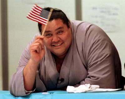 Akebono waves an American flag as he watches U.S. skaters in Nagano on Feb. 5, 1998, ahead of the Winter Olympics. 