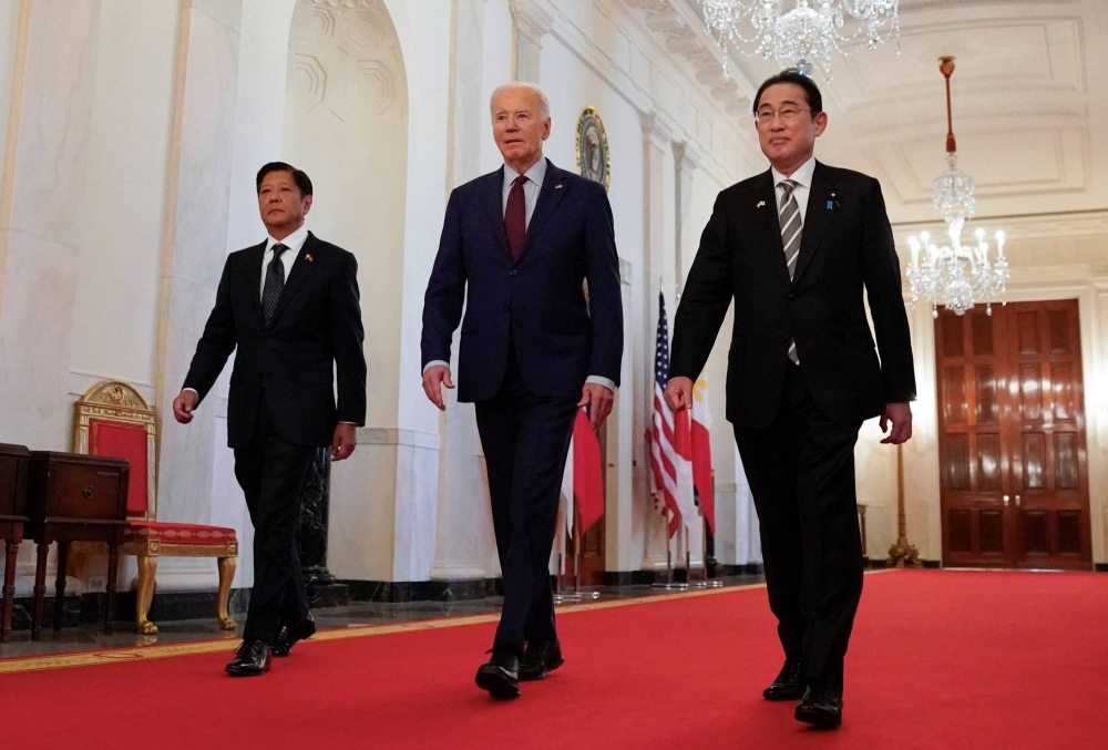 U.S. President Joe Biden escorts Philippine leader Ferdinand Marcos Jr. and Prime Minister Fumio Kishida to their trilateral summit at the White House in Washington on Thursday.