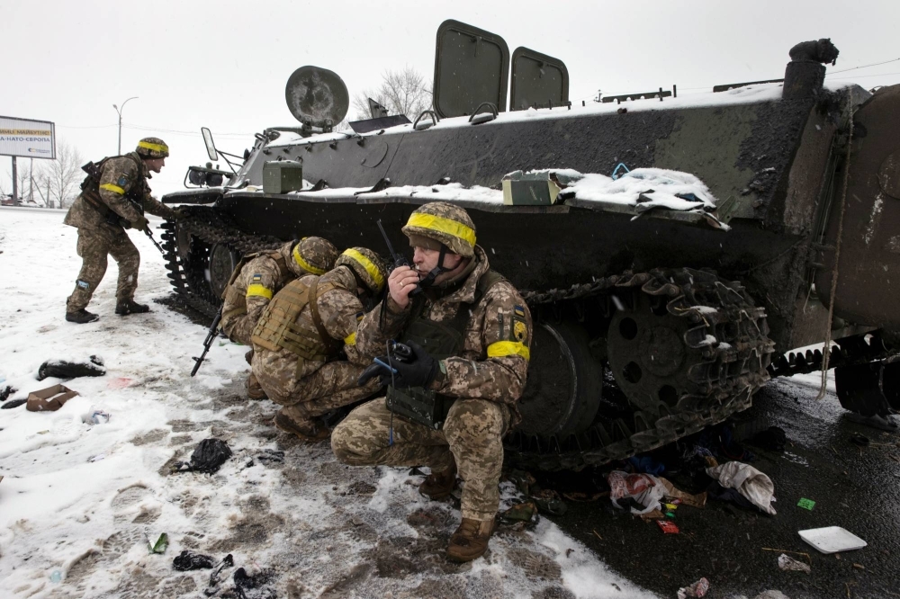 Ukrainian soldiers take cover during fighting in Kharkiv, Ukraine, on Feb. 25, 2022. 