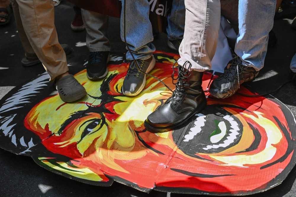 Protesters step on a caricature of Chinese leader Xi Jinping as they take part in a demonstration to condemn China's recent "aggressive actions" in disputed waters of the South China Sea, in front of the Chinese Consulate in Makati, Metro Manila, on Tuesday.