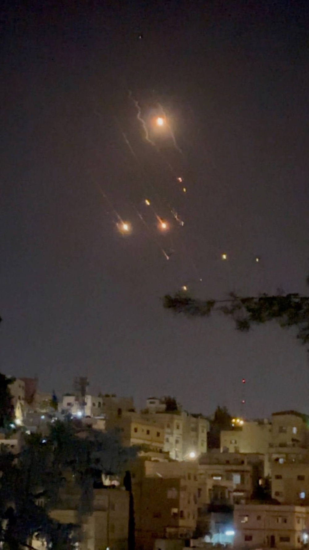 Objects are seen in the sky over Amman after Iran launched drones toward Israel, in Amman, Jordan, on Sunday, in this screen grab from a video on social media.