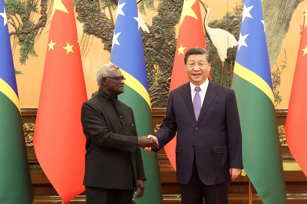 Solomon Islands Prime Minister Manasseh Sogavare and Chinese President Xi Jinping shake hands at the Great Hall of the People in Beijing on July 10.