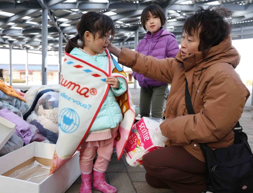 Residents of Wajima, Ishikawa Prefecture, collect supplies in the aftermath of the Jan. 1 earthquake. When it comes to preparing for and responding to disasters in Japan, the specific needs of women are still not being sufficiently met. One way to fix this would be to increase the number of women involved in the area of disaster prevention.