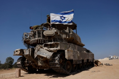 Israeli soldiers mount an Israeli flag on a military vehicle near the Israel-Gaza border on Monday.