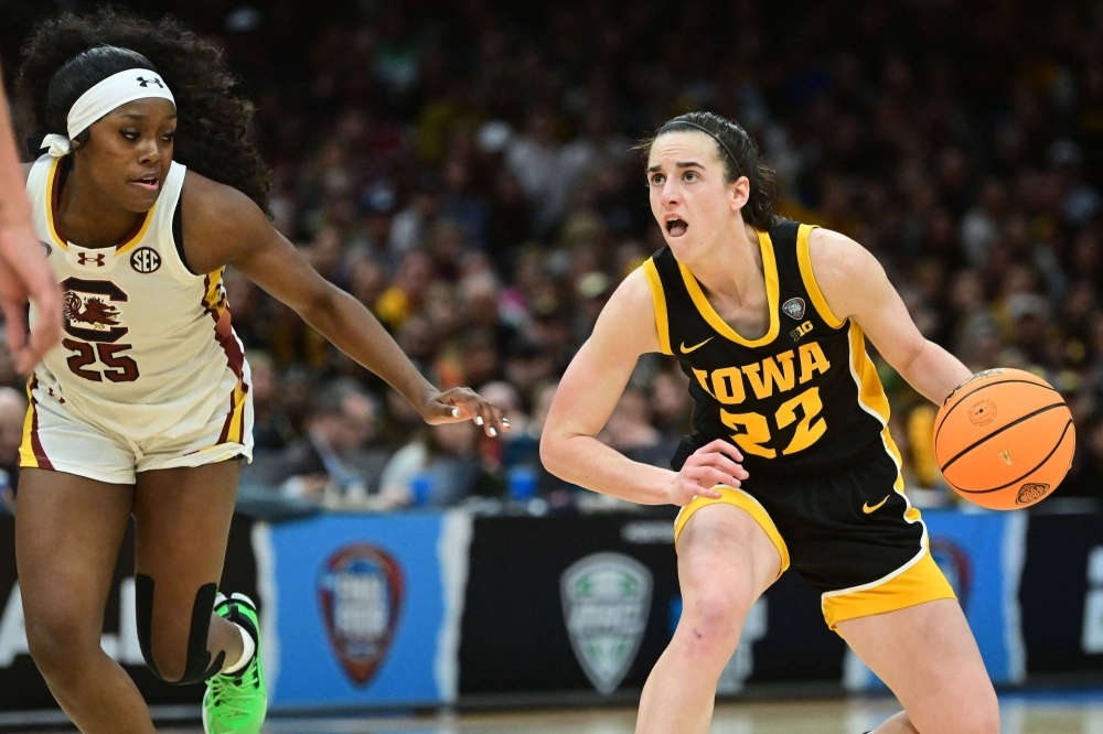 Iowa Hawkeyes guard Caitlin Clark (right) dribbles the ball past South Carolina Gamecocks guard Raven Johnson in Cleveland, Ohio, on April 7.
