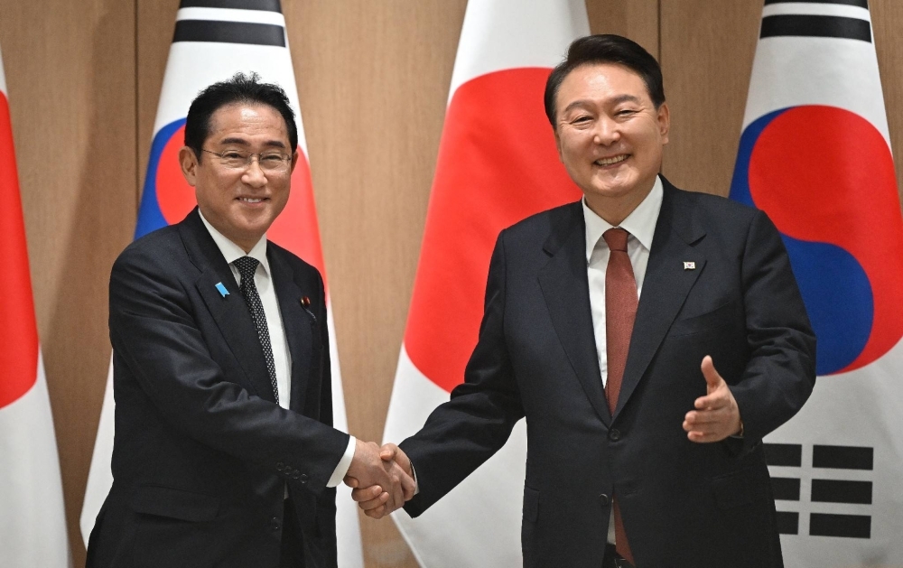 Kishida shakes hands with South Korean President Yoon Suk-yeol in Seoul in May 2023.
