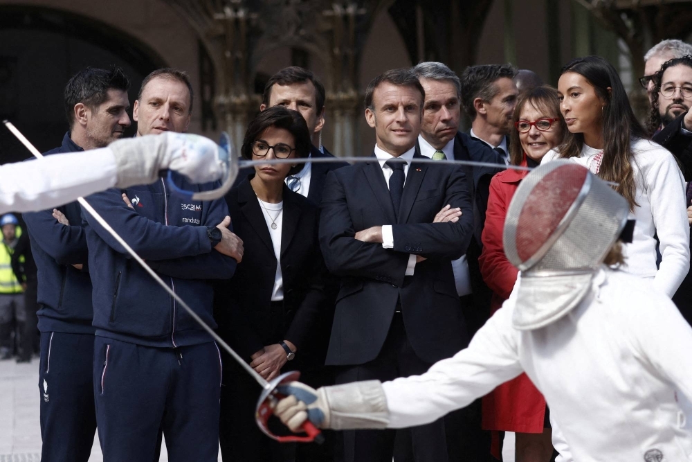 French President Emmanuel Macron with French fencing champion Sara Balzer and Minister of Culture of France Rachida Dati, as the president attends a demonstration by the French fencing team during his visit to the Grand Palais, 100 days ahead of the Paris 2024 Olympic Games on Monday.