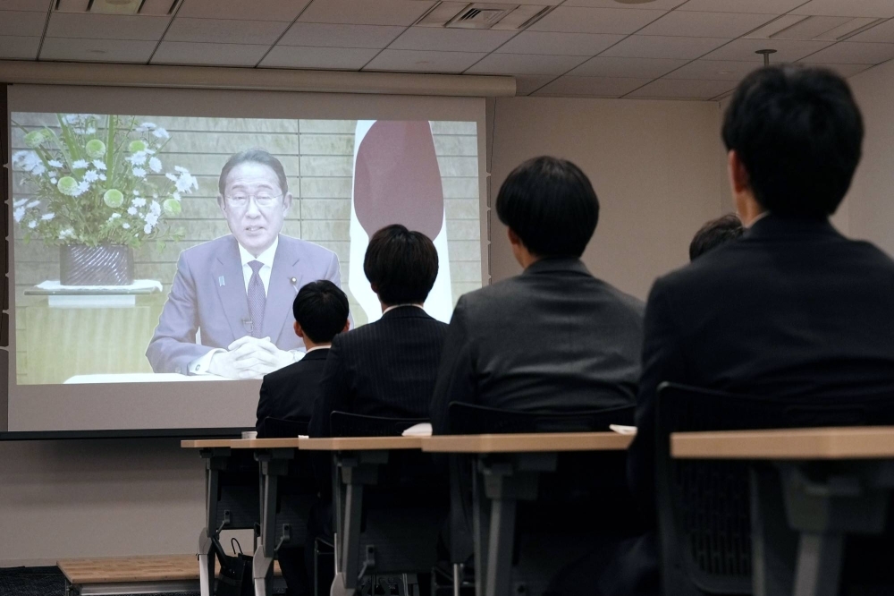Newly employed workers of government ministries and agencies listen to a video message by Prime Minister Fumio Kishida during a training session in Tokyo on April 3.