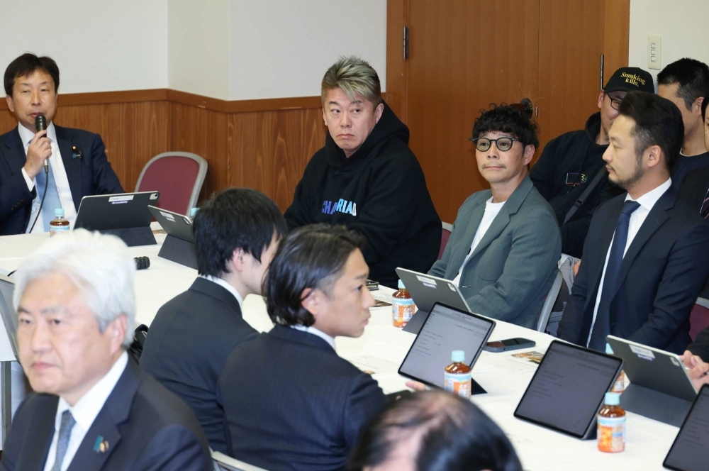Entrepreneurs Yusaku Maezawa (second from right) and Takafumi Horie (third from right) attend a study session on fake social media ads and investment scams at the Liberal Democratic Party headquarters in Tokyo on April 10.