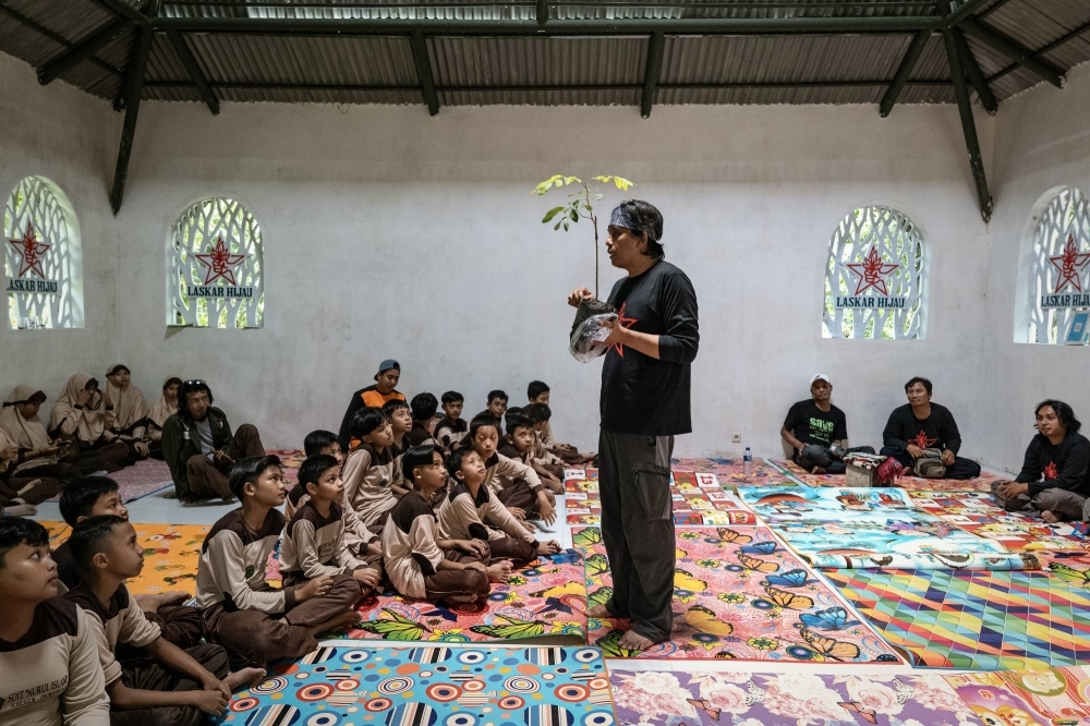 Aak Abdullah Al-Kudus, an environmentalist in East Java Province, discusses tree planting at an elementary school in Lumajang, East Java, Indonesia, in December 2023. A fatwa was issued against Aak after he tried to combine a tree-planting campaign with celebration of the Prophet Muhammad’s birthday.