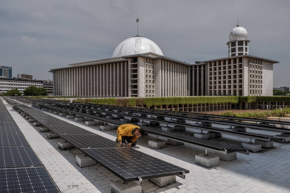 A worker inspects solar panels that provide electrical power to Istiqlal Mosque in Jakarta, Indonesia, in December 2023. High-ranking scholars and clergy have issued fatwas, or edicts, on how to rein in climate change. On a smaller scale, Muslim activists are telling their friends, family and neighbors that their duty to save the environment is embedded in the Quran.