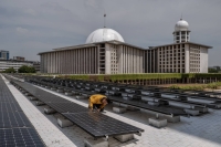 A worker inspects solar panels that provide electrical power to Istiqlal Mosque in Jakarta, Indonesia, in December 2023. High-ranking scholars and clergy have issued fatwas, or edicts, on how to rein in climate change. On a smaller scale, Muslim activists are telling their friends, family and neighbors that their duty to save the environment is embedded in the Quran. | Ulet Ifansasti / The New York Times