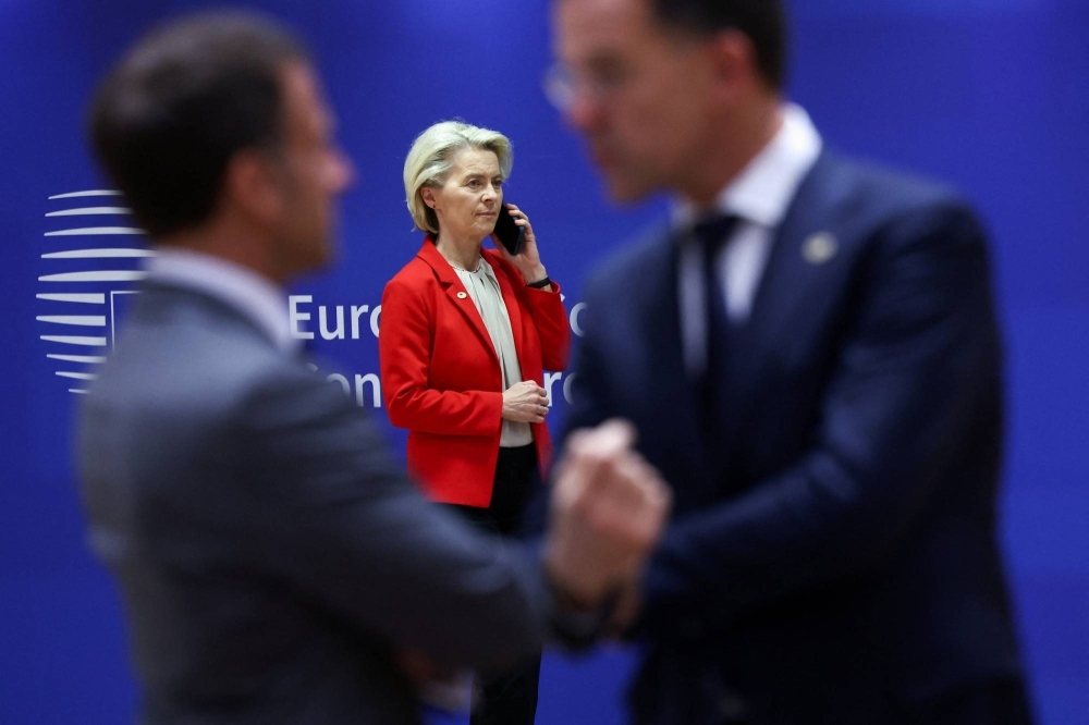 France's President Emmanuel Macron (left) and the Dutch Prime Minister Mark Rutte (right) talk as European Commission President Ursula von der Leyen (center) uses a phone during an informal European Union leaders' summit in Brussels on Wednesday.