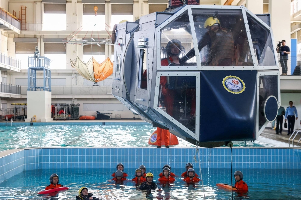 Taiwanese air force personnel take part in water survival and aviation egress training in a specialized pool at a base in Kaohsiung on Wednesday.