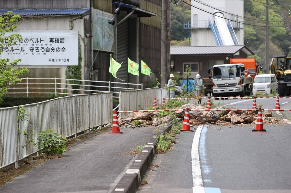 Национальная дорога заблокирована обвалившимися камнями в четверг после землетрясения магнитудой 6,6 в Одзу, префектура Эхимэ, произошедшего накануне.
