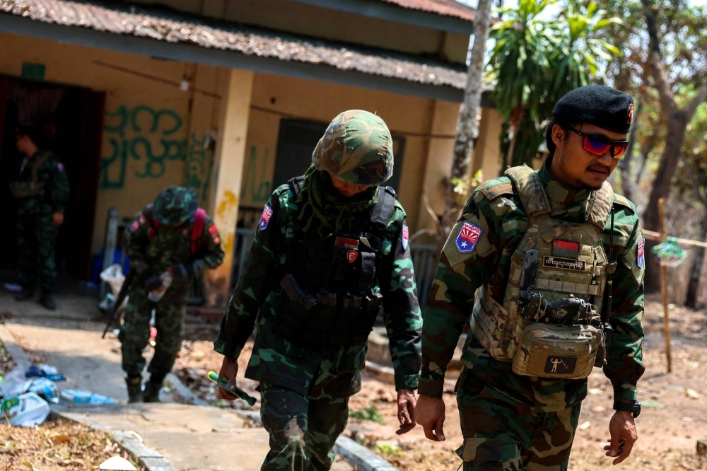 Lt. Saw Kaw, a soldier of the Karen National Liberation Army in charge of the Cobra column, walks with his team members after inspecting the house of a high-rank Myanmar soldier at Infantry Batallion 275 at Myawaddy in Myanmar on Monday.