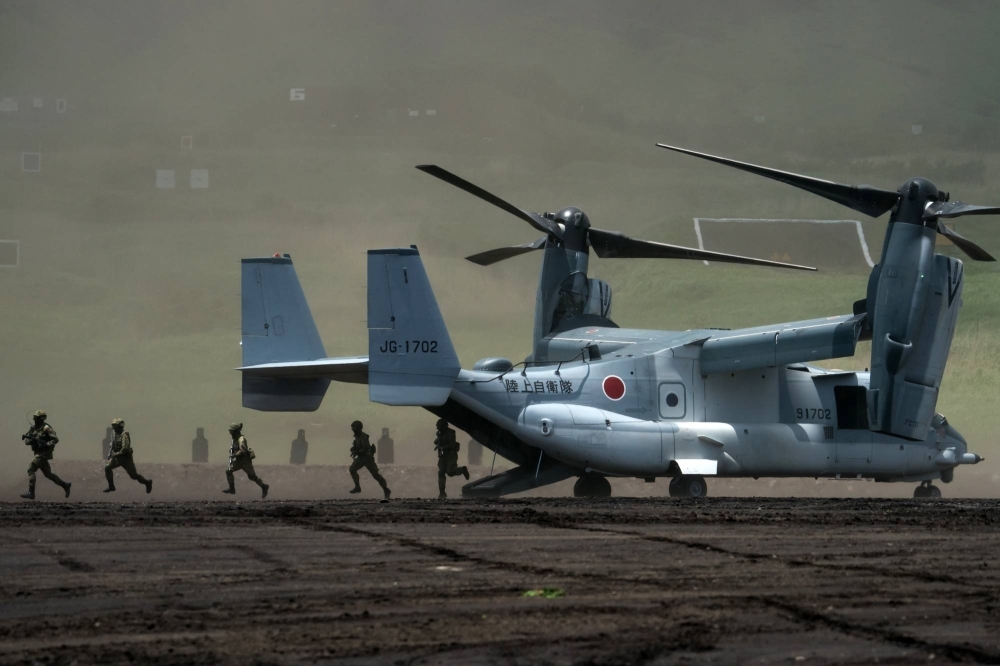 Members of the Ground Self-Defense Force disembark from a V-22 Osprey aircraft during a live fire exercise in Gotemba, Shizuoka Prefecture, in May 2022.