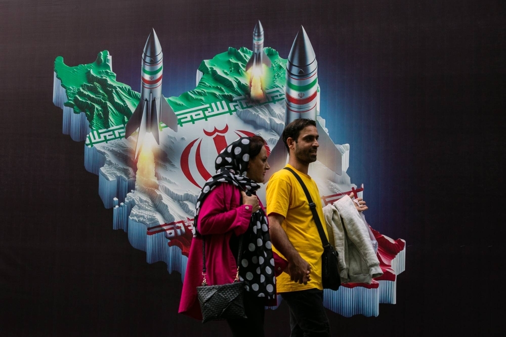 People walk past a mural depicting Iranian missiles in Tehran on Thursday.  