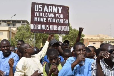 Protesters react as a man holds up a sign demanding that soldiers from the United States Army leave Niger without negotiation during a demonstration in the capital, Niamey, on April 13.