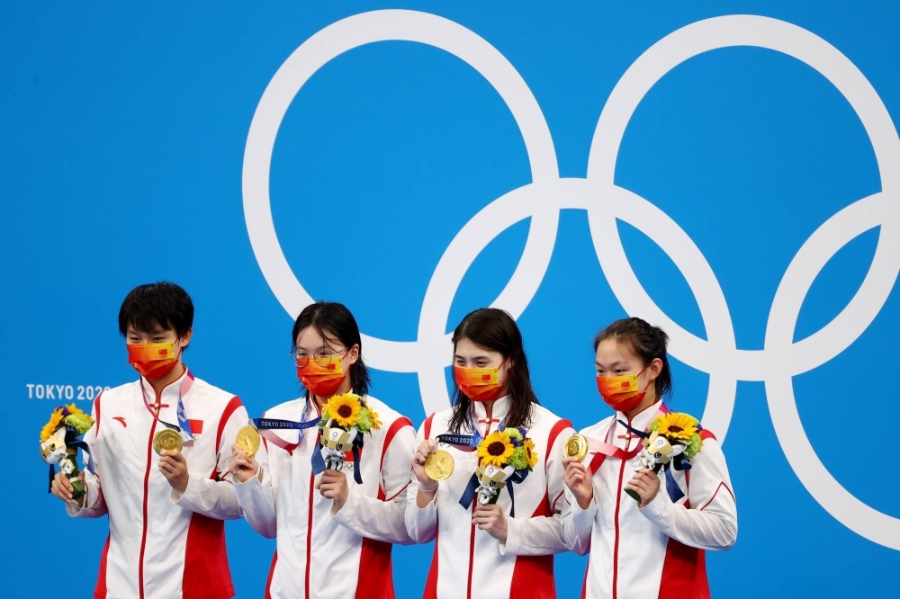 China's Olympic gold-medal winning 4 x 200 meter freestyle relay team celebrates on the podium at the Tokyo Aquatics Centre on July 29, 2021.  Zhang Yufei (third from left) is among 23 top Chinese swimmers who tested positive for a banned substance in the lead up to the Games.  