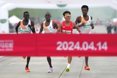 From left: Willy Mnangat, Robert Keter, He Jie and Dejene Hailu Bikila cross the finish line in the Beijing half-marathon on April 14. He crossed first but the top three were later disqualified after it appeared they let He win.