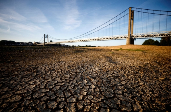 Cracked and dry earth in the wide riverbed of the Loire River near the Anjou-Bretagne bridge, amid a heat wave in Ancenis-Saint-Gereon, France, in 2022