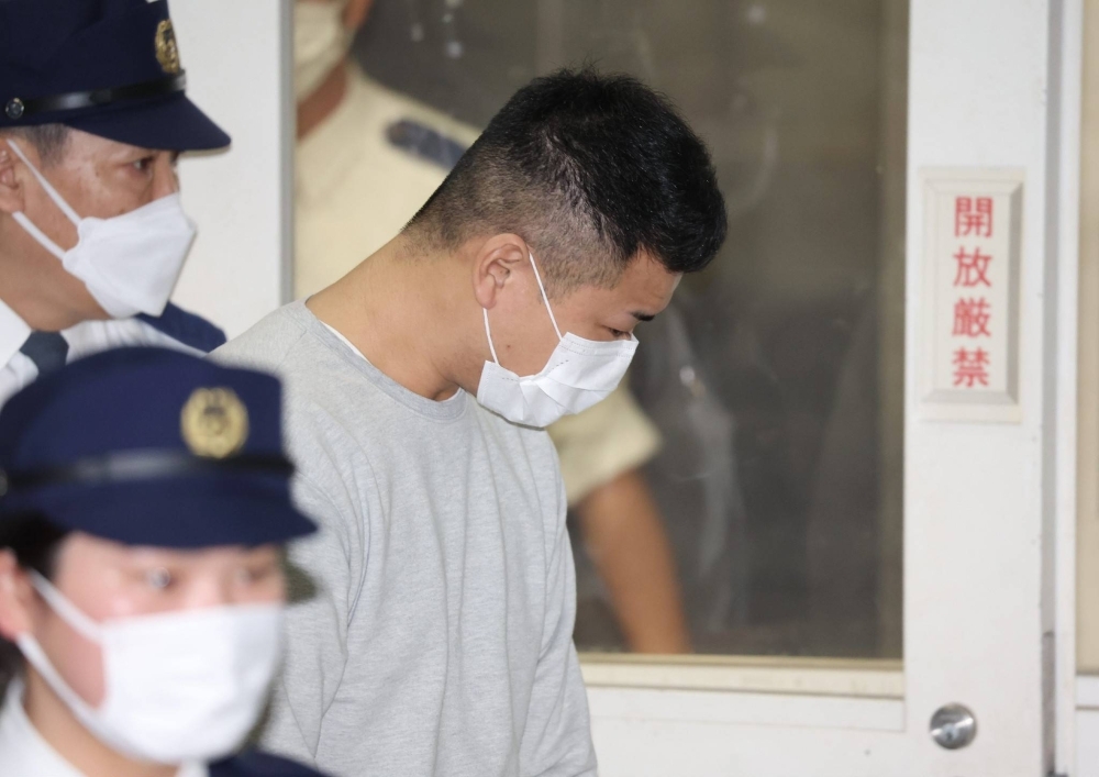 Ryoken Hirayama, a construction worker arrested in connection with the discovery of the two charred bodies in Tochigi Prefecture, leaves a Tokyo police station on Monday. He has been handed over to prosecutors.