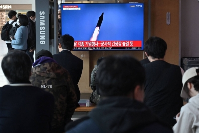 People watch a television screen showing a news broadcast with file footage of a North Korean missile test, at the main railway station in Seoul, on April 2.