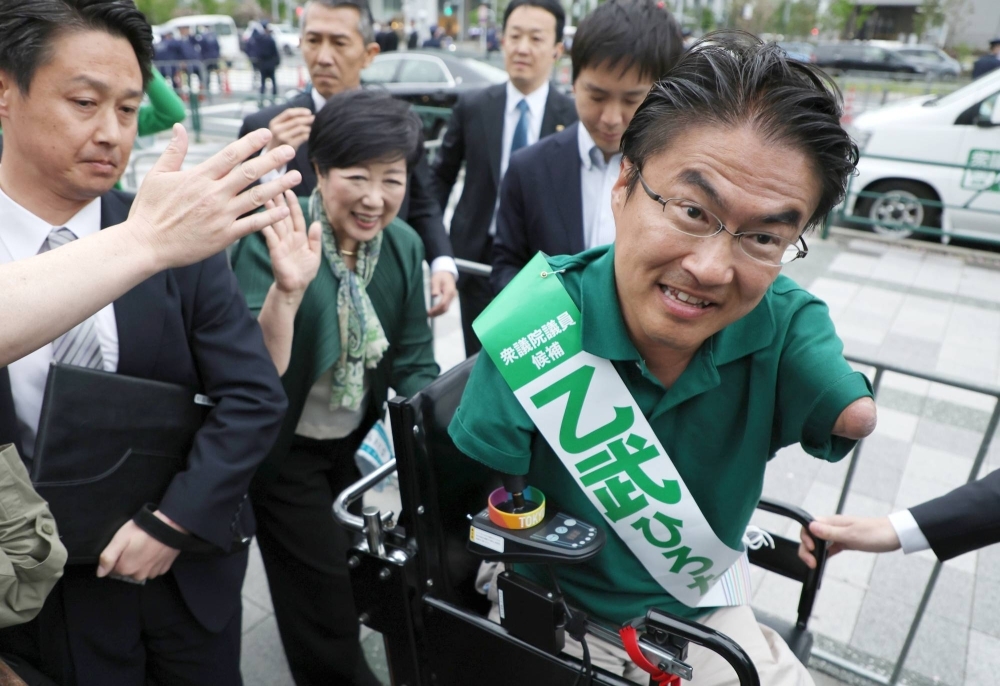 Hirotada Ototake interacts with voters during a campaign stop in Tokyo's Koto Ward on Sunday.