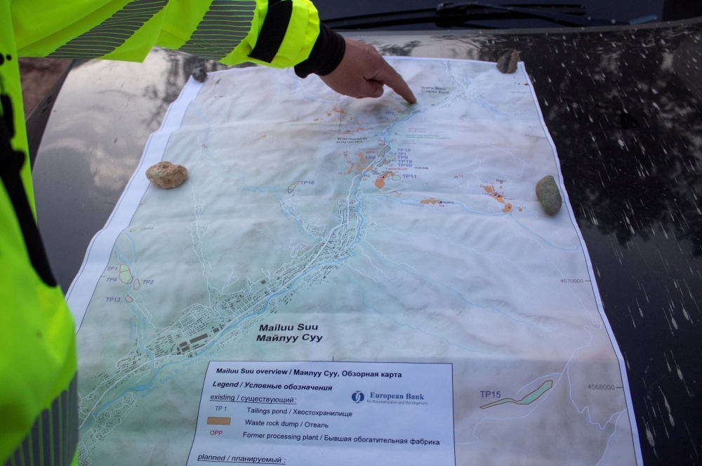 Sebastian Hess, an engineer with German firm G.E.O.S. contracted by the Kyrgyz government, shows the terrain map during a meeting with journalists near Mailuu-Suu in the Jalal-Abad region, Kyrgyzstan.
