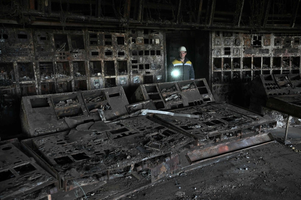A worker walks through a burned out control room at a power plant of energy provider DTEK. A Russian attack blew off parts of the roof and ripped through walls, severing vital communications systems and sparking several blazes.