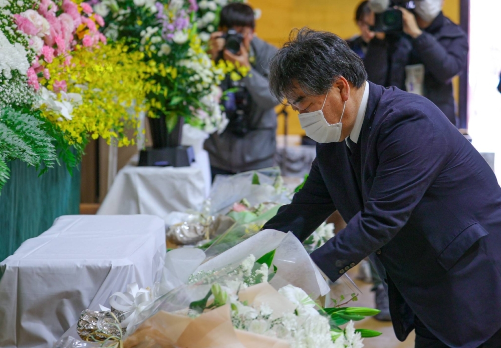 A man offers flowers in Shari, Hokkaido, Tuesday for the victims of the fatal sinking of a sightseeing boat off the Shiretoko Peninsula in Hokkaido two years ago.