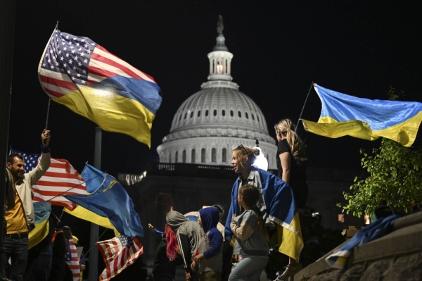 People who stand in solidarity with Ukraine wave flags and hold signs outside the U.S. Capitol in Washington, on Tuesday. The Senate on Tuesday voted overwhelmingly to move toward a final vote on the long-stalled $95 billion package of aid to Ukraine, Israel and Taiwan.
