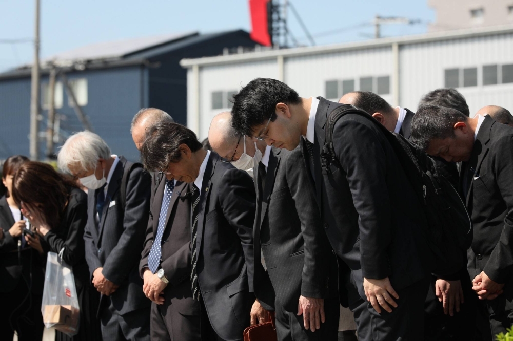 People observe a moment of silence for the victims of a JR Fukuchiyama Line train crash in Amagasaki, Hyogo Prefecture, Thursday morning on the 19th anniversary of the accident.